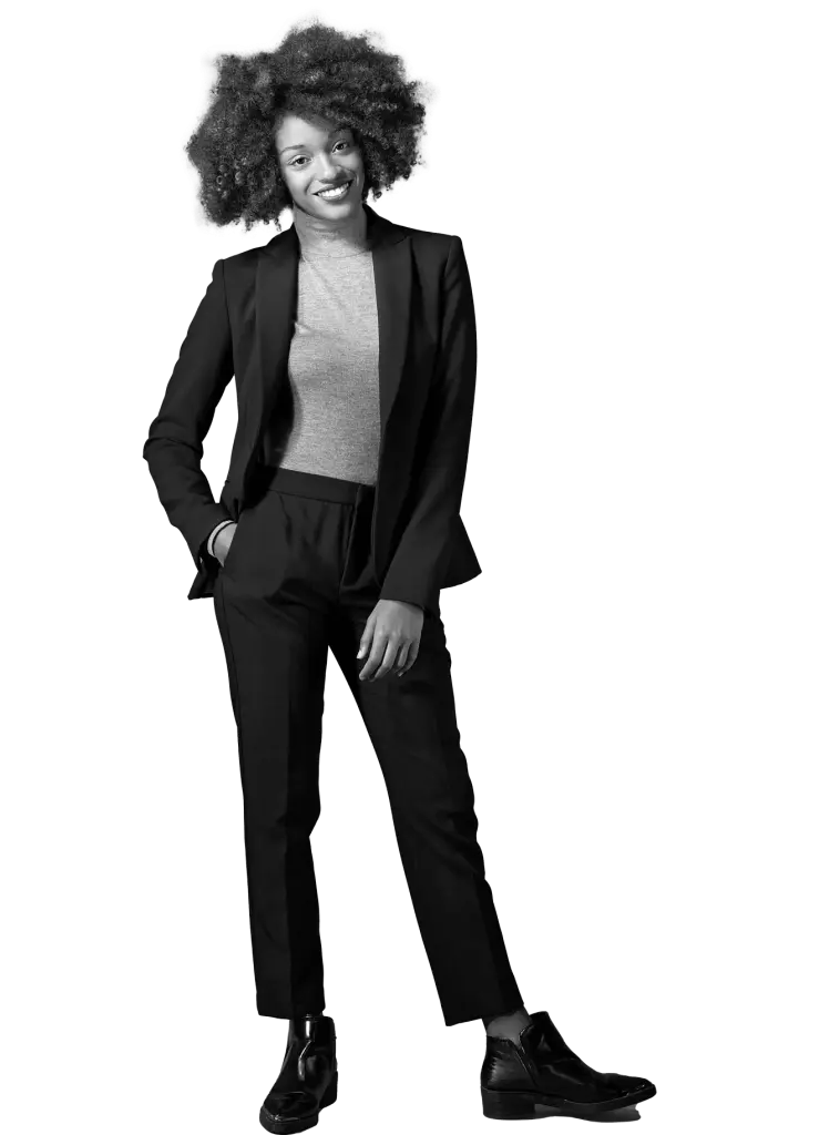 Woman with curly hair in a black suit standing with her hands in her pockets